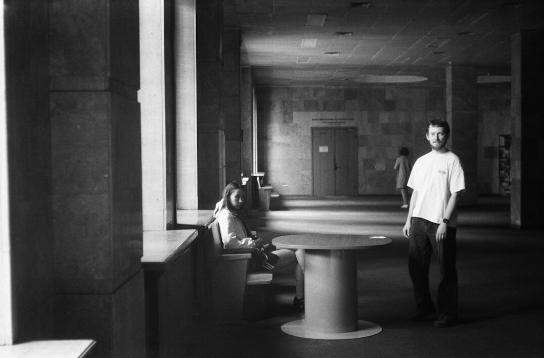 Two colleagues having a friendly conversation in an office hallway
